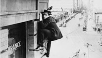 Harold Lloyd hangs precariously from a building in the silent film 'Safety Last'