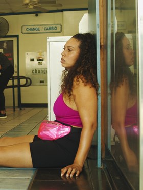 Film still from I'm Fine (Thanks For Asking), the main character Danny is slumped in a laundromat with roller skates on