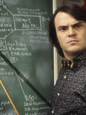 School of Rock - man stood in front of blackboard