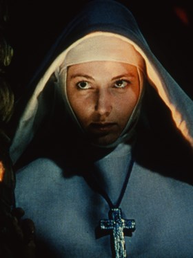 A medium close up of a nun looking off-camera.